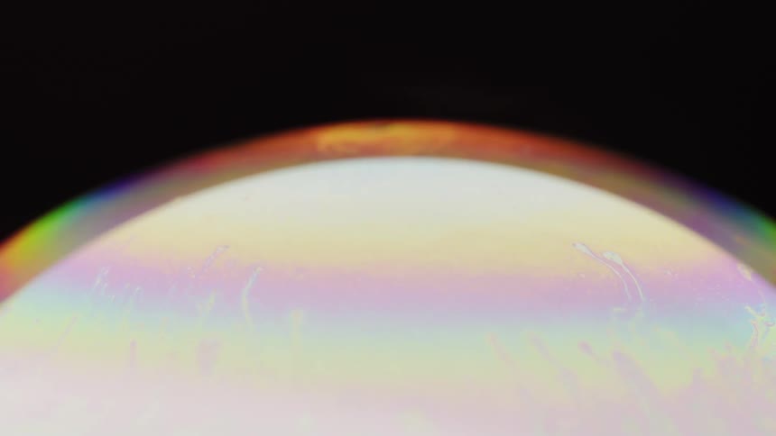 A glowing sphere covered in rainbow colors in space