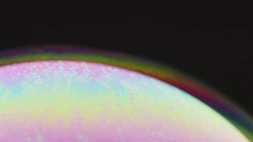 A sphere is covered in soft pastel stripes moving across the surface as an aurora glows from the globe in the darkness