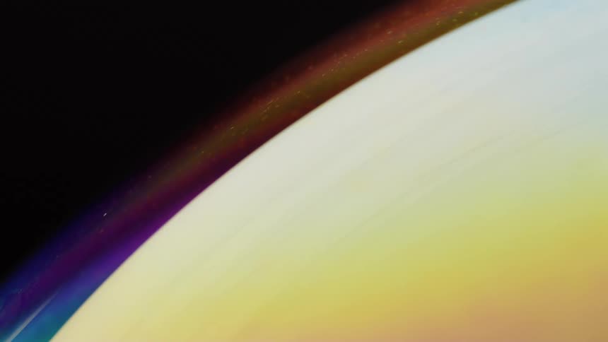 A sphere in space like a planet with different rainbow colors at night