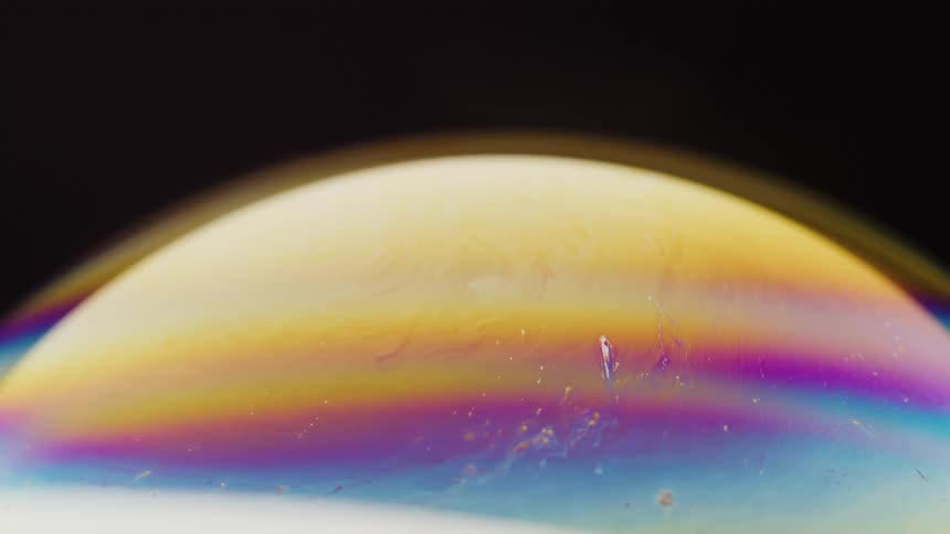 Yellow purple and light blue sphere turning around on a black background