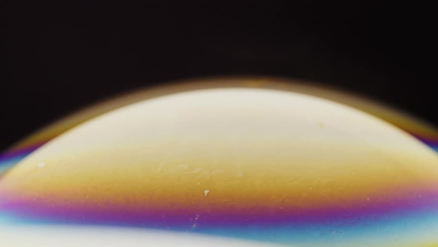 Colorful atmosphere glows between top of sphere and surrounding blackness
