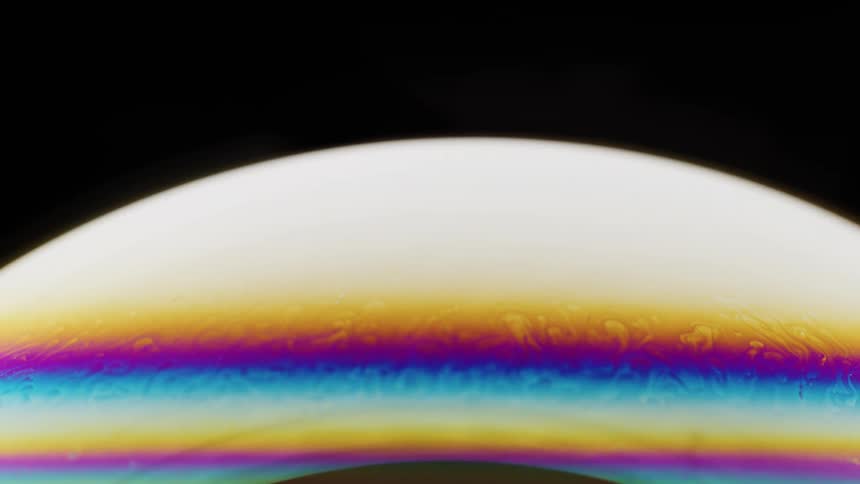 Rainbow colored lines appear in front of a donut shaped light