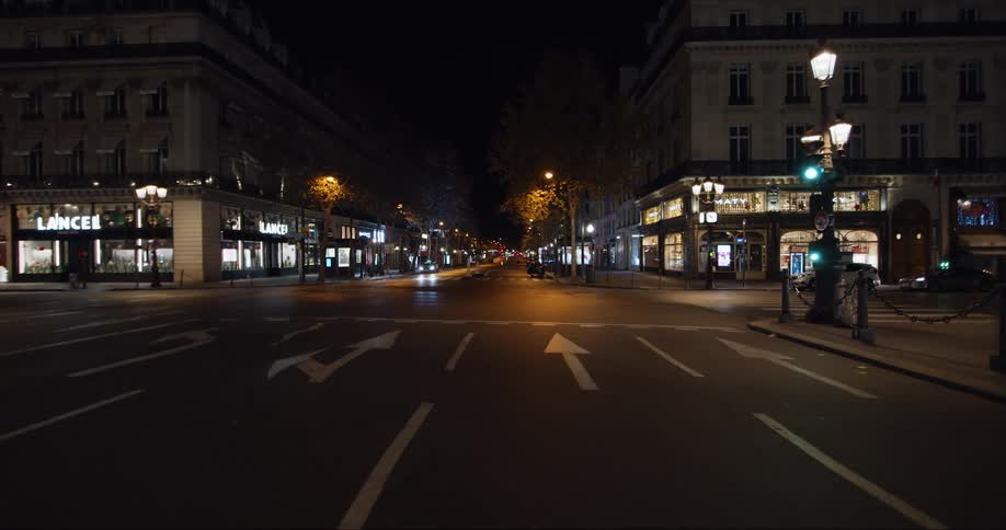 The street is lined with store fronts with bright lights lighting up the windows