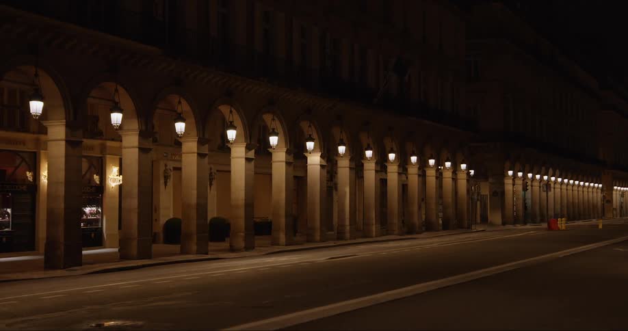 Outside of a long building with many pillars at night