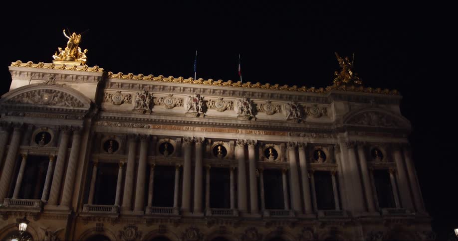 An historical building with many pillars at night