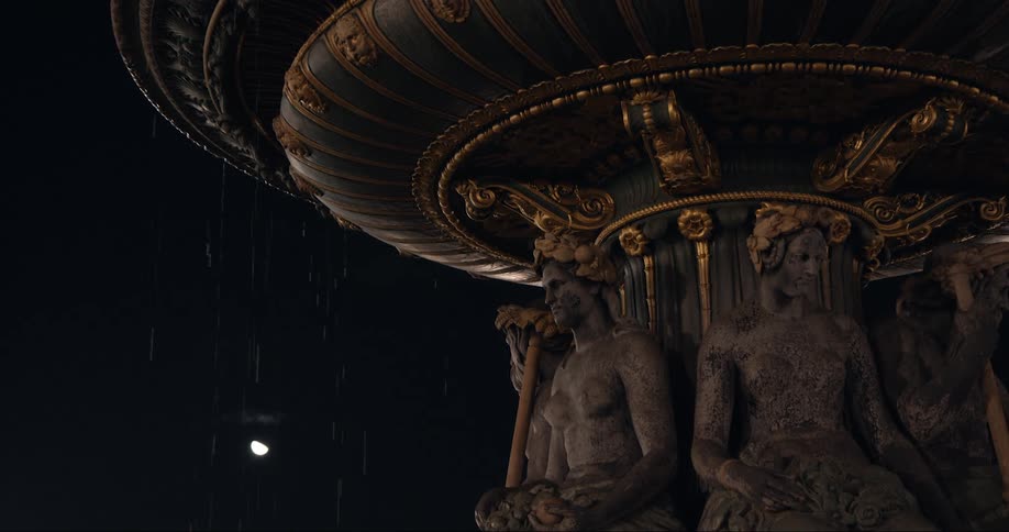 Rain falls over a large outdoor sculpture