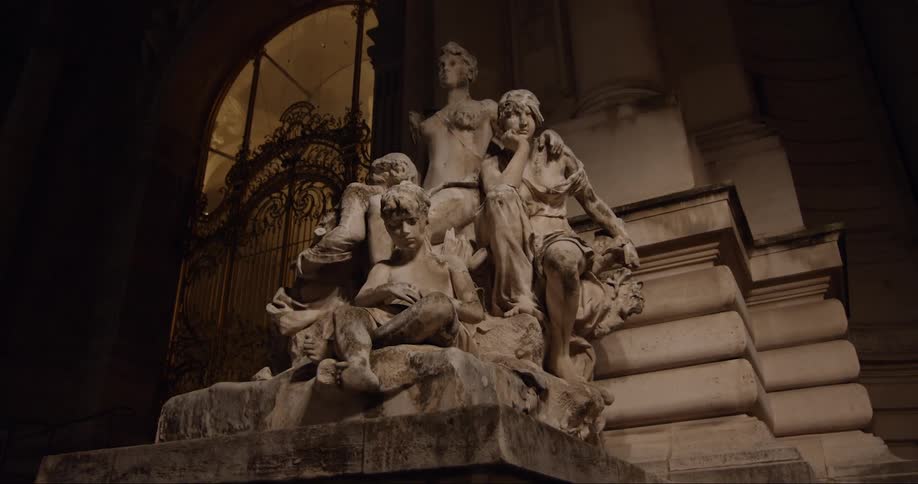 Historical monument in the form of statues of people in an outdoor setting at night