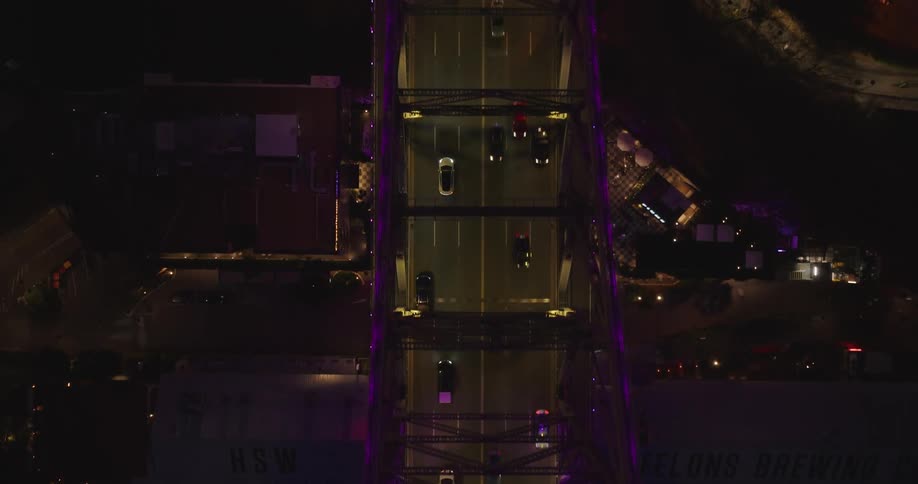 Aerial view of a bridge at night with vehicles moving across