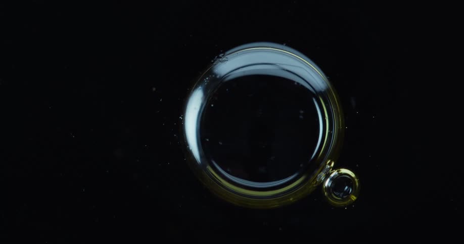 Large bubble next to a small one in a dense liquid on a black background