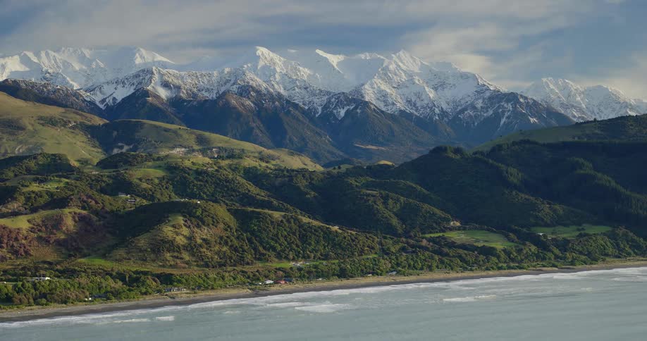 Aerial view of a river with a snowy mountain range in the distance