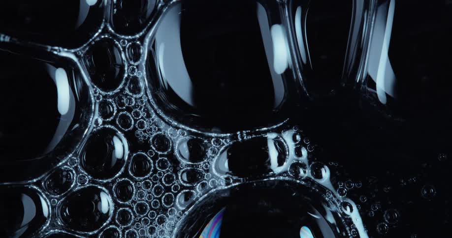 Light shines on bubbles on a dark surface