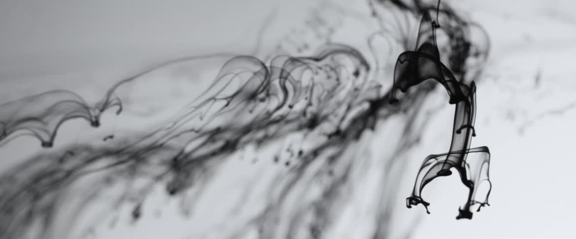 Black smoke slowly falling on a white background