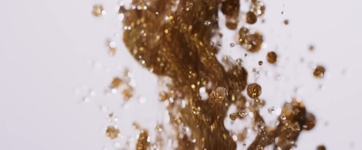 The gold liquid falls and bounces