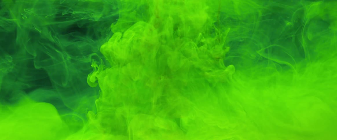 Glowing green smoke and toxic waste fills the atmosphere as it spreads