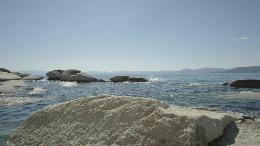A man jumps off a rock diving in the water