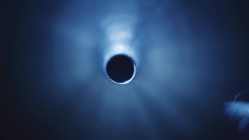 A black hole on a blue surface that turns dark when a shadow passes by