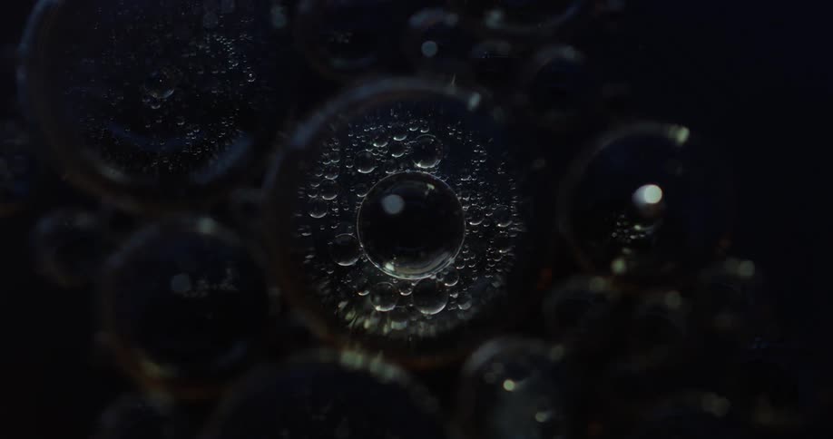 Liquid bubbles on an abstract black background