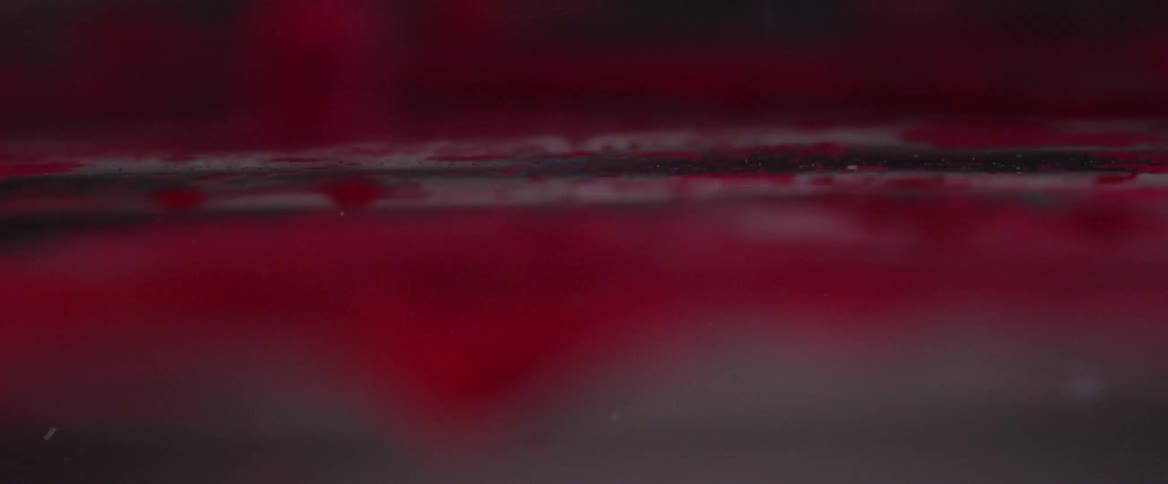 Dense black and red liquid in abstract motion