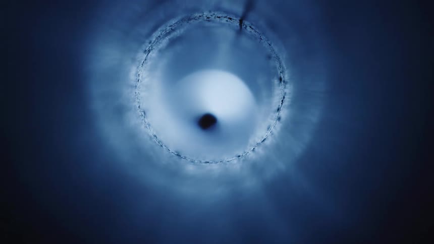 A vision of a dark blue tunnel being illuminated by a strong light