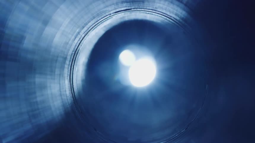 A flare of light passing through a tube in a dark environment