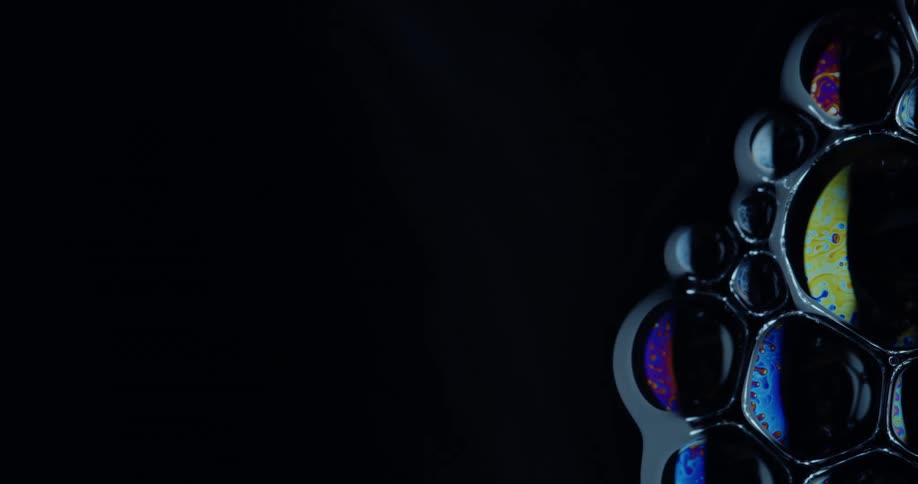 Several bubbles stuck together and with different colors inside them on a black background