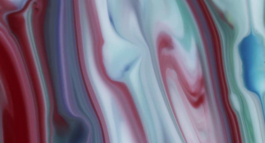A liquid substance of colors swirl as they mix and blend in stripes