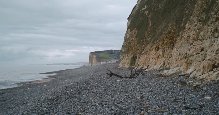 A pebble beach with cliffs on a cloudy day