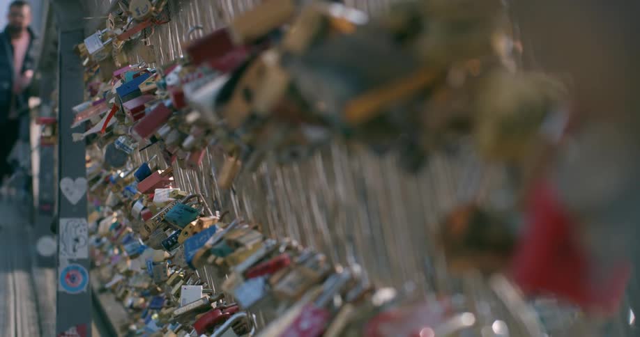 Multiple padlocks locked to a metal gate at midday