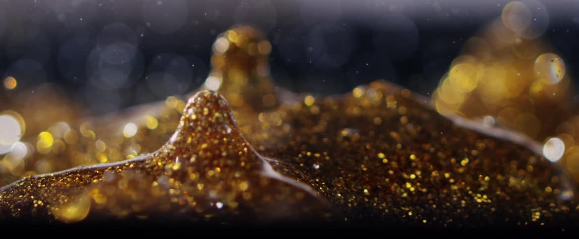 Abstract and dense golden droplet falling and returning
