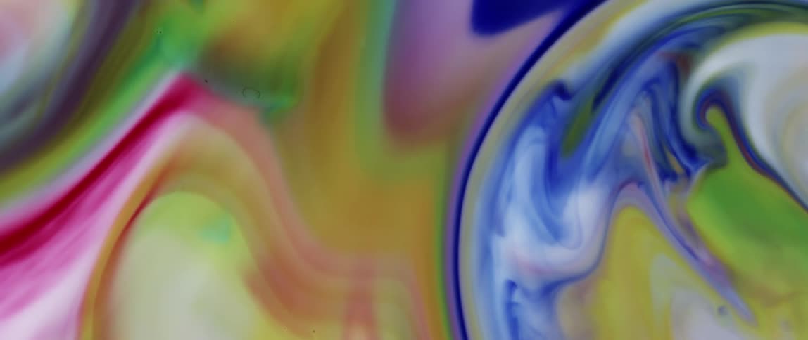 Liquids of multiple colors swirling together and against each other but not mixing
