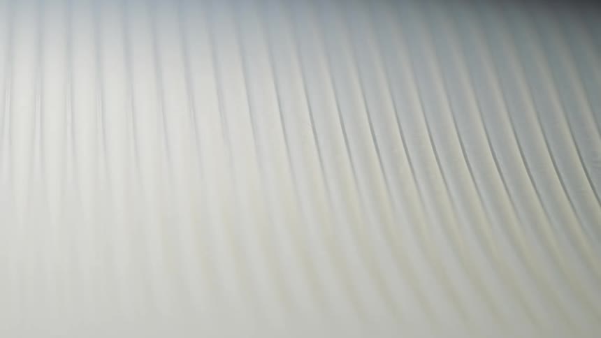 Light shining on pleated ivory fabric