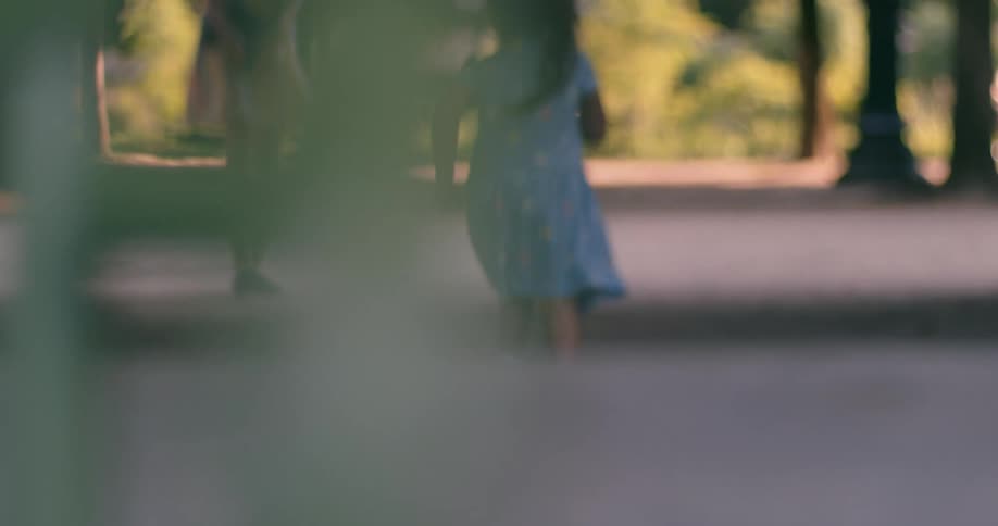 A kid running in a park at midday scaring birds away