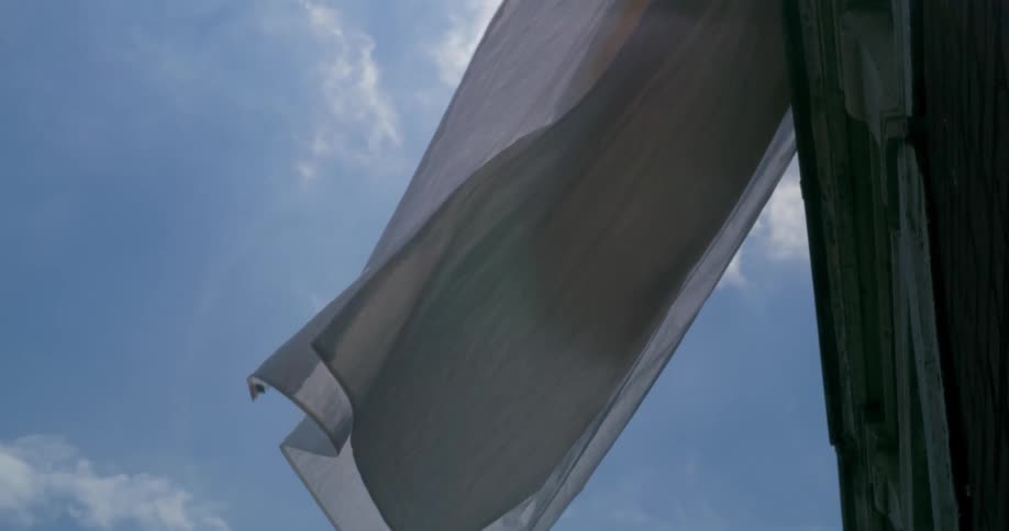 White cloth waves against a blue sky