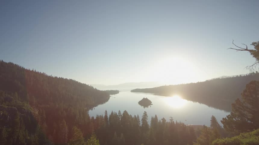 Trees and hills lead to a lake below