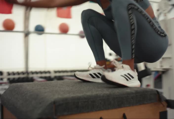 Woman doing box jumps in an indoor gym