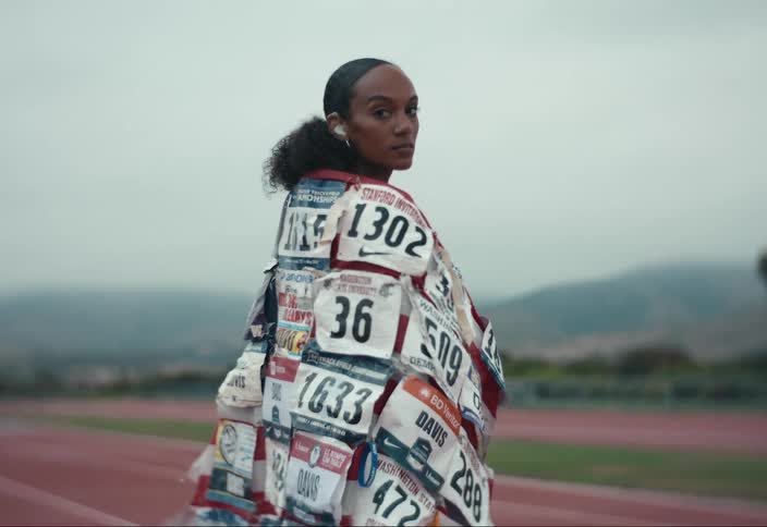 A woman standing outside on a track with a flag