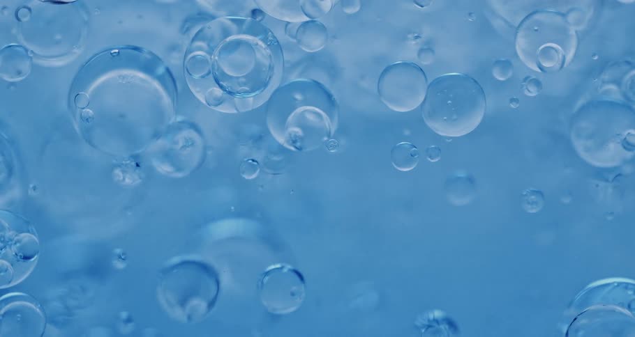 Groups of bubbles floating in blue liquid