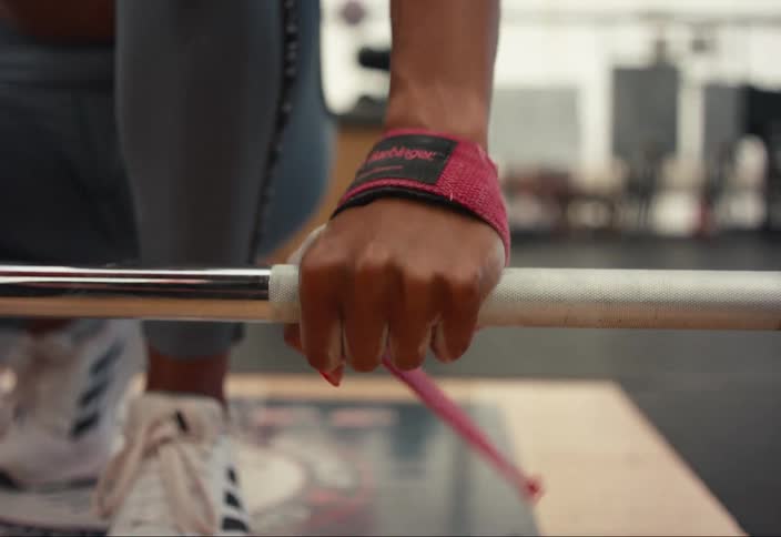 A woman is lifting weights in a gym