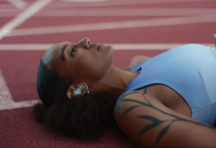 A young woman lying down on the track after a race