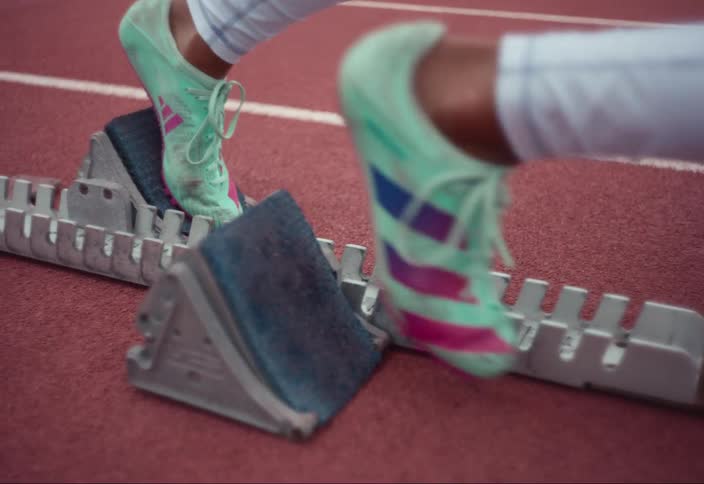 Close up of a person's shoes placing them on a track preparing to take off running