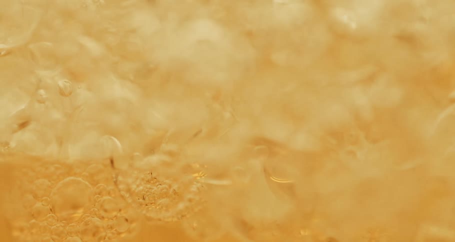 Dense orange liquid with abstract bubbles in motion