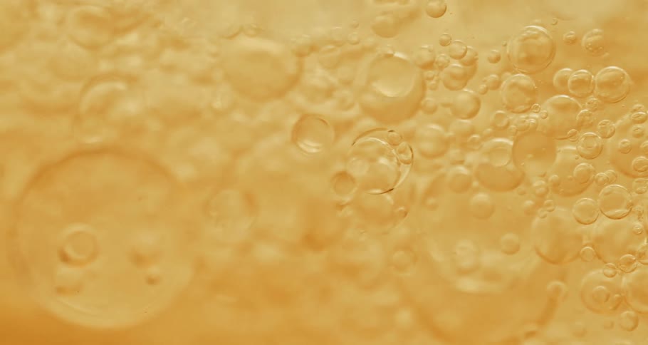 Translucent tapioca pearls flow through pale peach mixture