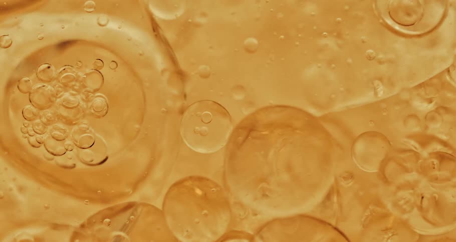 Air bubbles rising on a thick yellow liquid