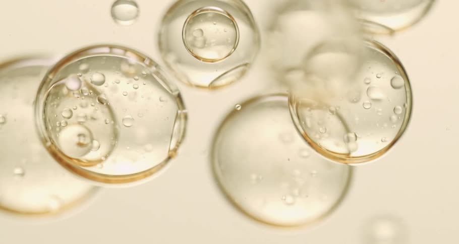 Clear bubbles slowly moving around and being poured into a clear liquid