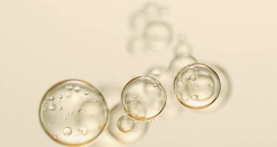 Clear orbs with bubbles floating inside cast a shadow as they move over a flat surface