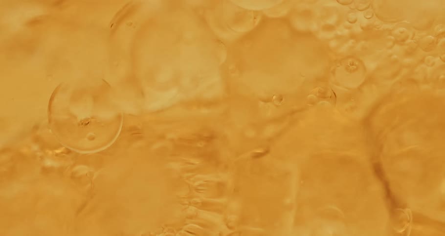 Orange liquid with various abstract bubbles in motion