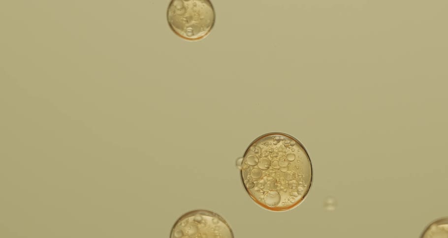 Circular clusters of yellow bubbles floating in liquid