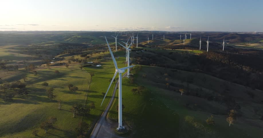 Road passes through wind farm located on hilly terrain