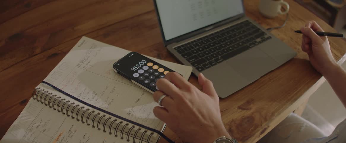 Man uses his phone as a calculator while working from home