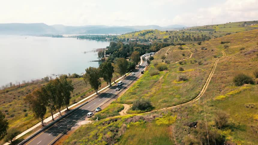 Cars on a road in a grassy field by the ocean